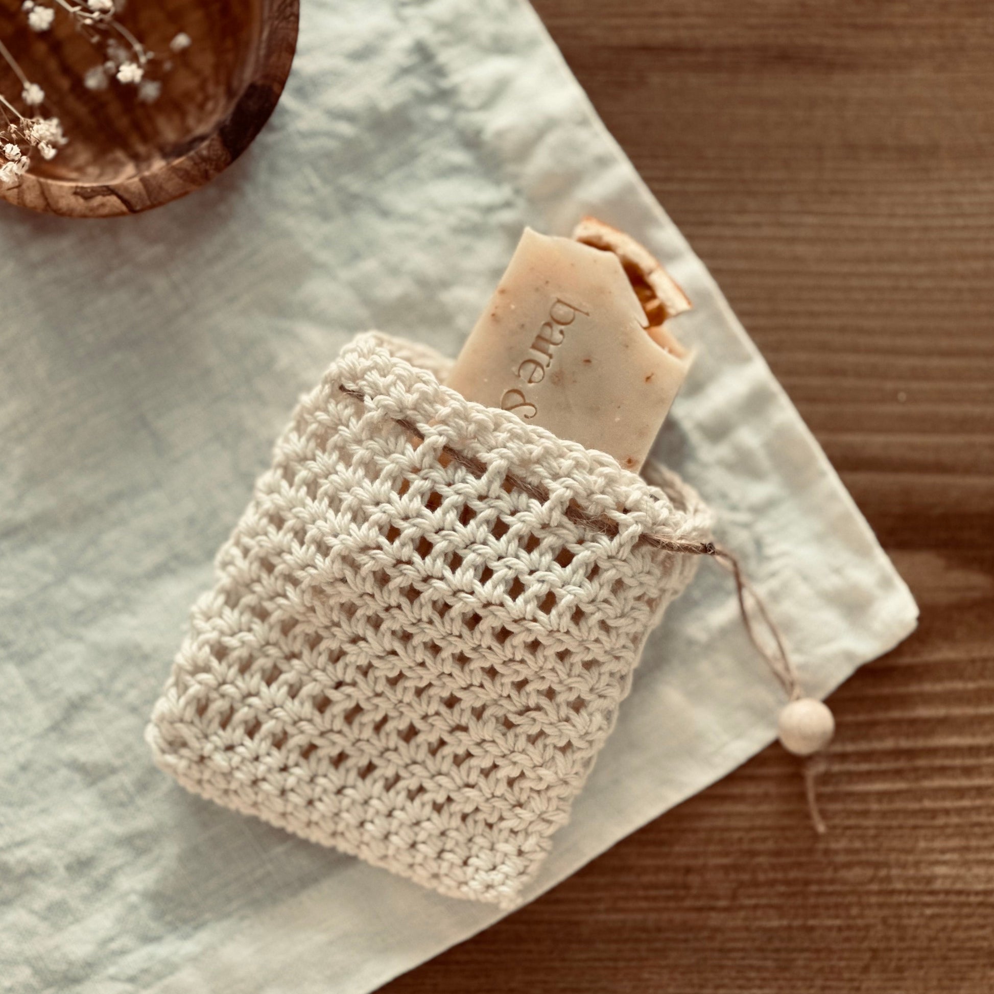 small soap in a hand crocheted organic soap bag