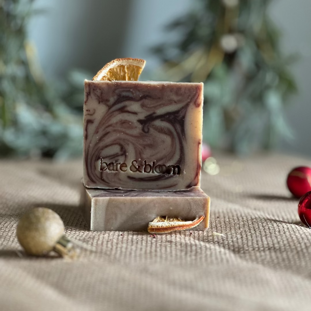 Seasonal Marble-patterned soap bar with 'bare & bloom' branding on a textured surface with decorative elements.