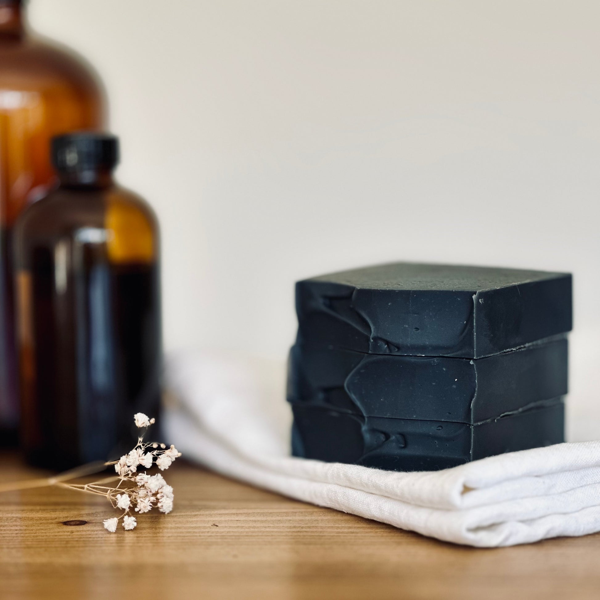 stack of 3 charcoal soap on white cloth
